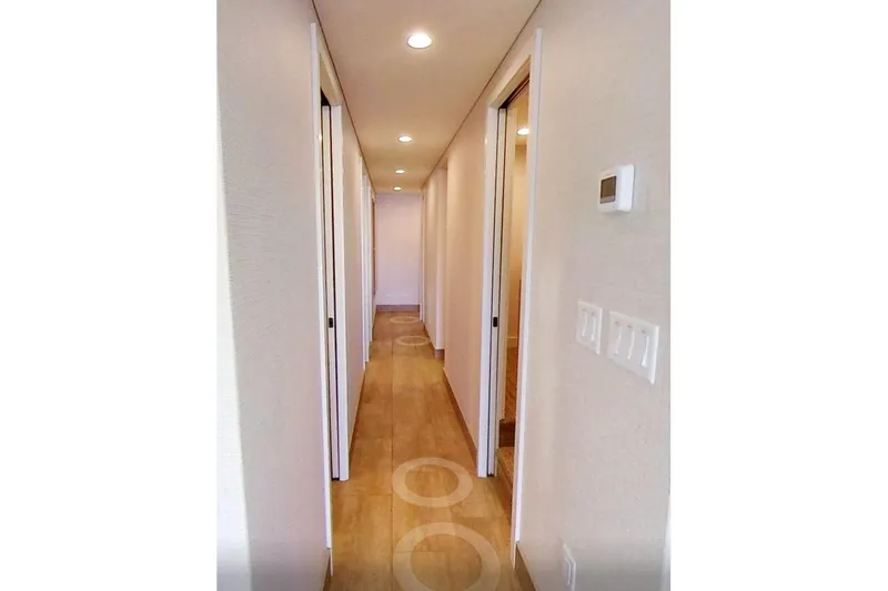 Slide: The Image of Modern hallway with wooden flooring, recessed lighting, and white walls in Adonia Radiance Share #3, 2022. - 7