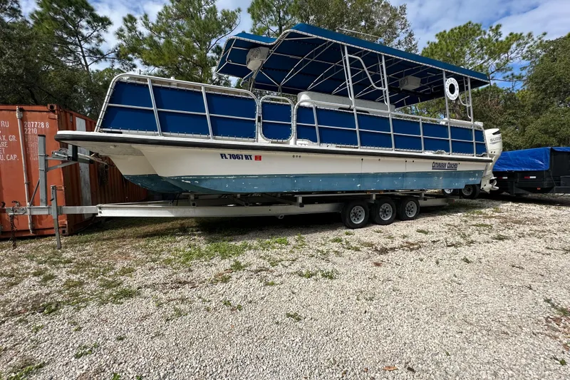 Slide: The Image of 1999 Catamaran Coaches 31 boat on trailer, blue canopy, parked outdoors. - 1