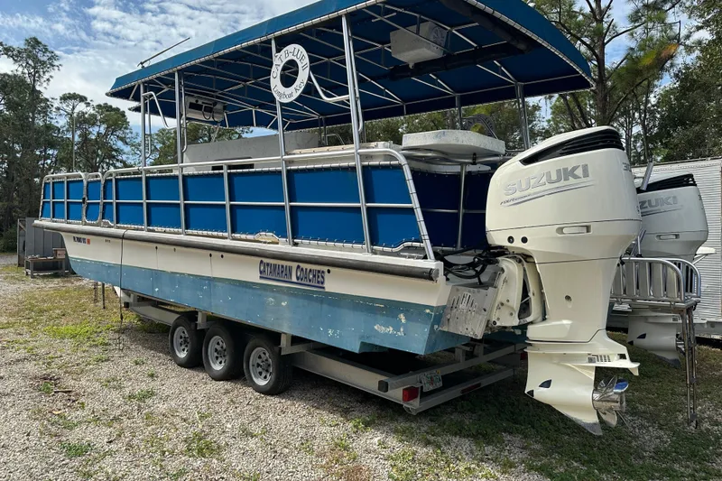 Slide: The Image of 1999 Catamaran Coaches 31 boat with Suzuki outboard engines on a trailer. - 5