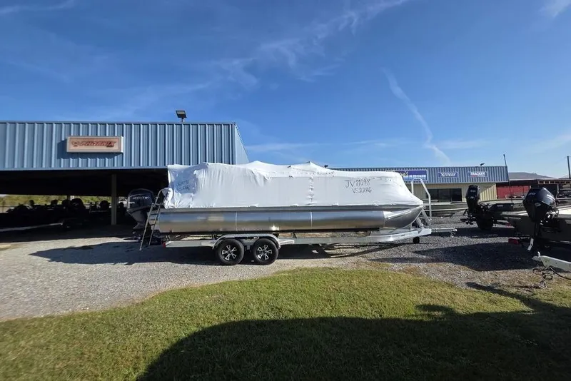 Slide: The Image of 2026 Veranda Vista 22RC pontoon boat covered, parked outdoors under clear blue sky. - 6