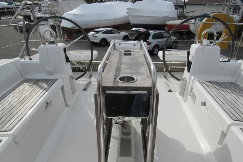 Slide: The Image of 2017 Beneteau Oceanis 41.1 yacht cockpit with dual steering wheels and wooden table. - 39