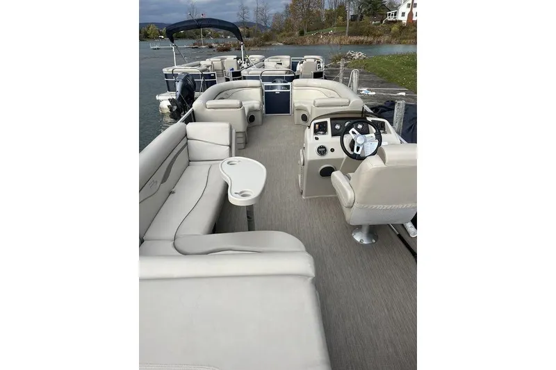 Slide: The Image of 2018 Bennington 23SLX pontoon boat with spacious seating and modern helm on a calm lake. - 14