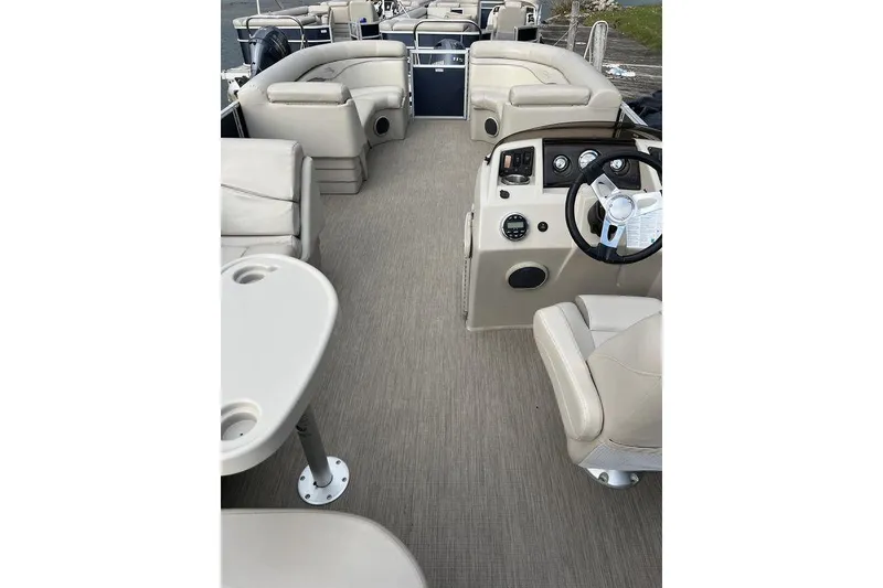 Slide: The Image of 2018 Bennington 23SLX pontoon boat interior with beige seating and steering console. - 4