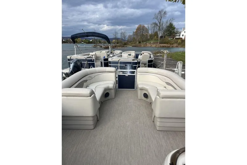 Slide: The Image of 2018 Bennington 23SLX pontoon boat with spacious seating on a calm lake. - 7