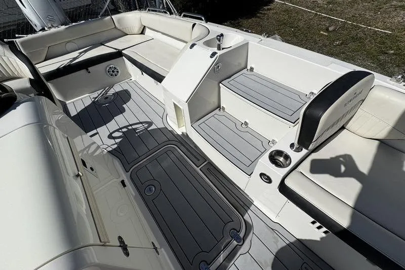 Slide: The Image of 2022 Stingray 212SC boat interior with seating, steps, and cup holders. - 11