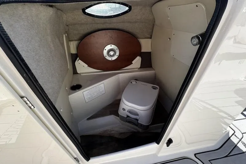 Slide: The Image of 2022 Stingray 212SC boat interior with compact toilet and storage area. - 15