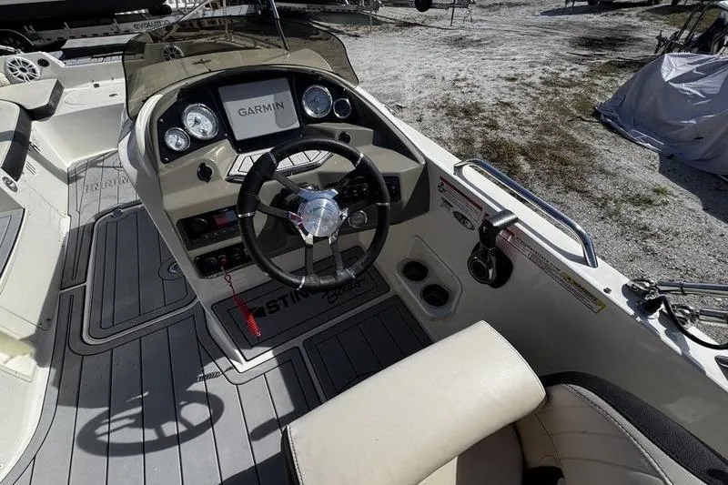 Slide: The Image of 2022 Stingray 212SC boat cockpit with Garmin navigation system and steering wheel. - 16