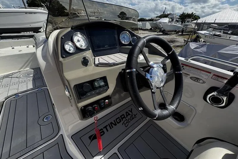 Slide: The Image of 2022 Stingray 212SC boat dashboard with steering wheel and control panel. - 18