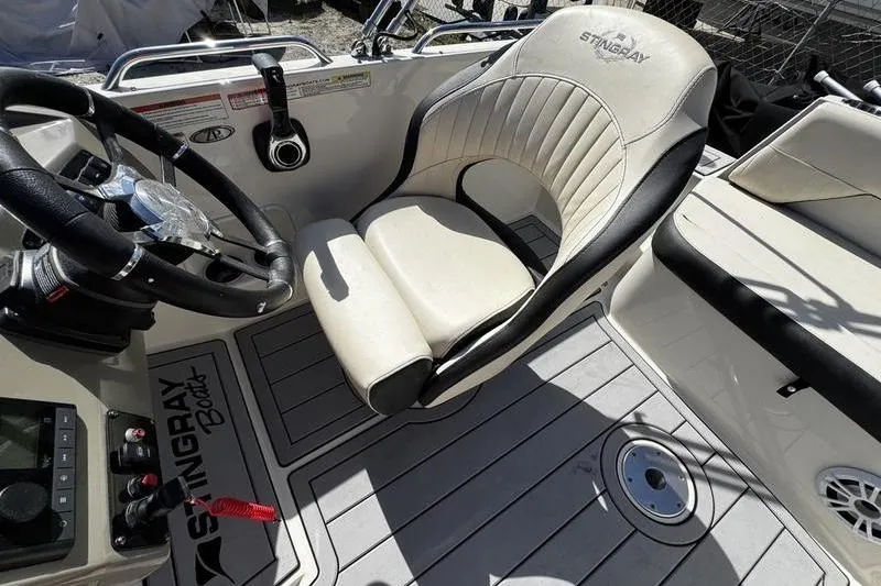 Slide: The Image of 2022 Stingray 212SC boat interior with steering wheel and cushioned seat. - 20