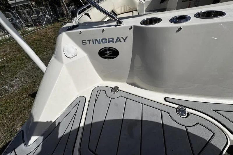 Slide: The Image of 2022 Stingray 212SC boat deck with cup holders and branding. - 25