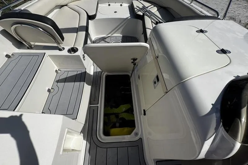 Slide: The Image of 2022 Stingray 212SC boat interior with open storage compartments and seating. - 27