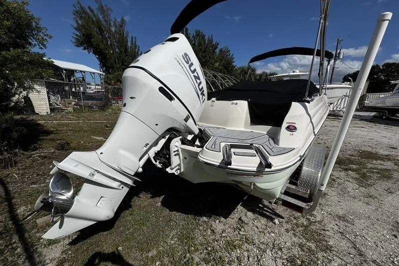 Slide: The Image of 2022 Stingray 212SC boat with Suzuki outboard motor, parked on a trailer. - 28