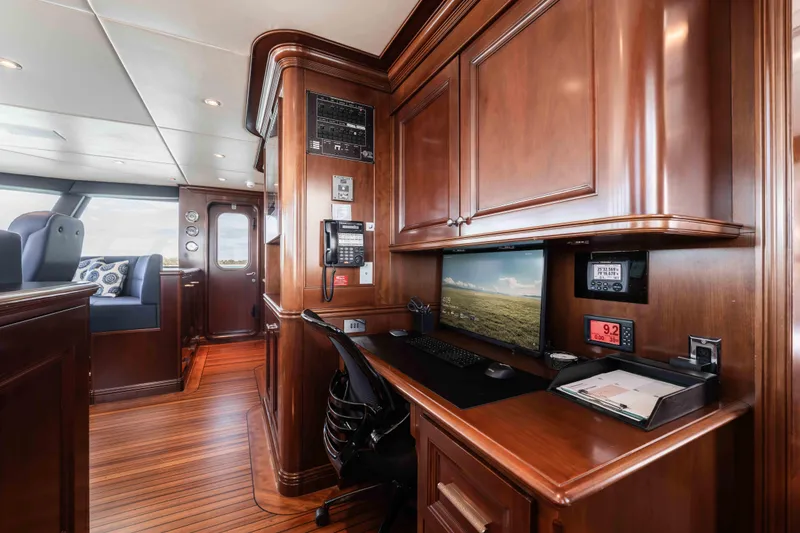 Slide: The Image of Luxurious 2004 Trinity Yachts motor yacht interior with elegant wood paneling and modern workspace. - 34