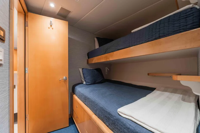 Slide: The Image of Bunk beds in 2004 Trinity Yachts motor yacht cabin with wooden door and blue bedding. - 40