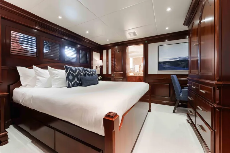 Slide: The Image of Luxurious bedroom interior on 2004 Trinity Yachts motor yacht with elegant wood paneling. - 16