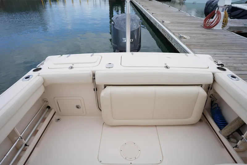 Slide: The Image of 2016 Grady-White Freedom 225 boat interior at dock, featuring seating and storage compartments. - 17