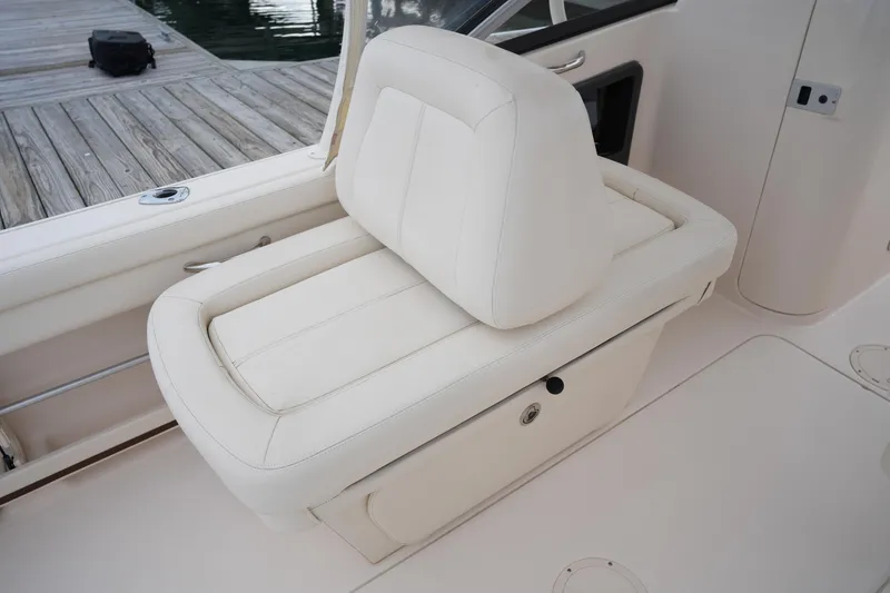 Slide: The Image of 2016 Grady-White Freedom 225 boat seat with white upholstery, dockside view. - 19