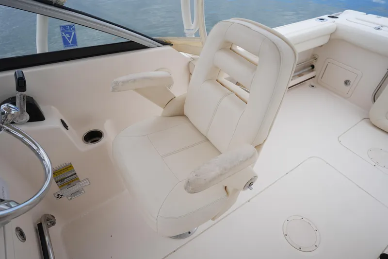 Slide: The Image of Captain's chair on 2016 Grady-White Freedom 225 boat, featuring white upholstery and armrests. - 21