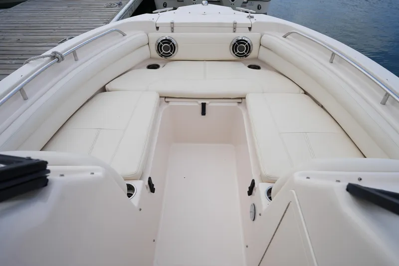 Slide: The Image of 2016 Grady-White Freedom 225 boat interior with white cushioned seating and cup holders. - 30