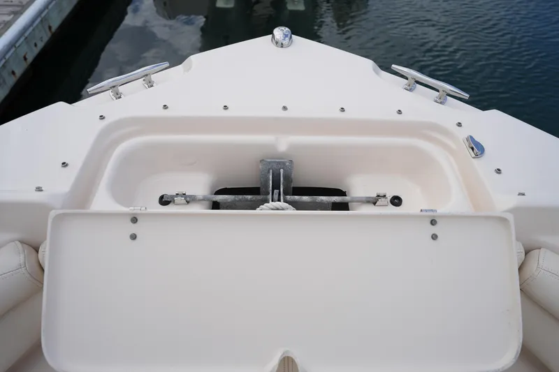 Slide: The Image of 2016 Grady-White Freedom 225 boat anchor compartment, docked on calm water. - 33