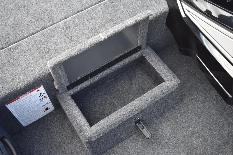 Slide: The Image of 2026 Lowe Stinger 175C boat storage compartment with carpeted interior and safety instructions. - 11