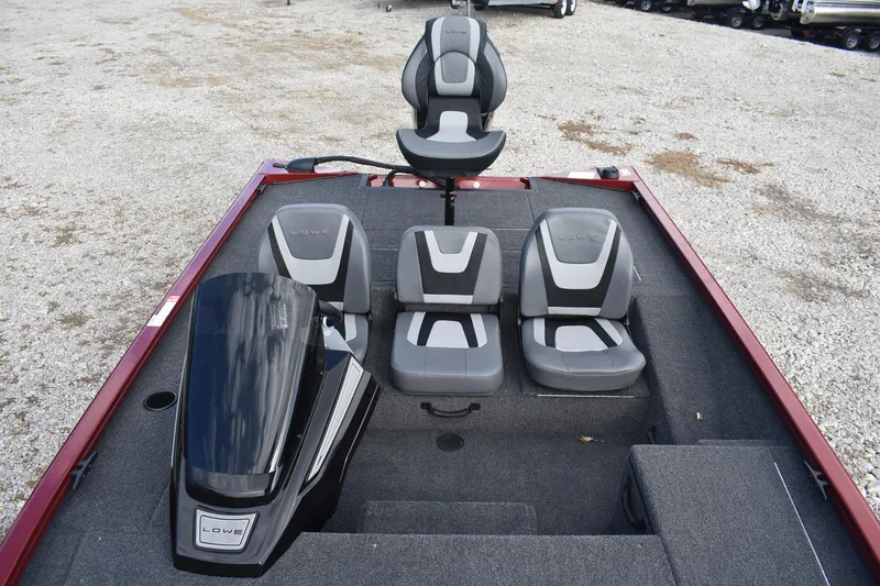 Slide: The Image of 2026 Lowe Stinger 175C boat interior with four gray seats on a gravel surface. - 15