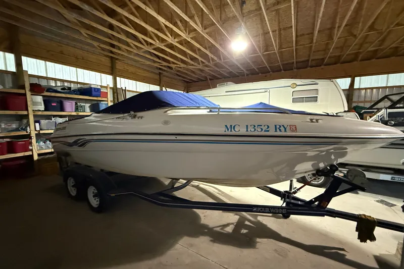 The Image of 1999 Four Winns 220 Horizon boat in storage, covered and on a trailer. - 0
