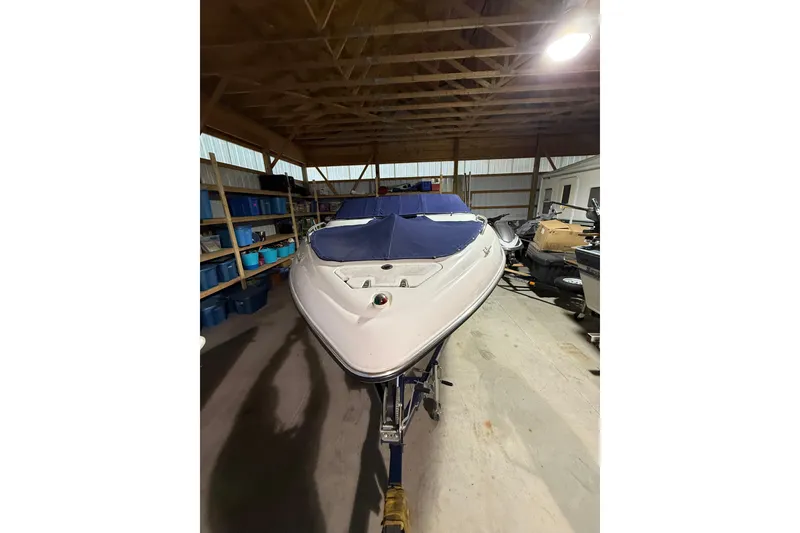 Slide: The Image of 1999 Four Winns 220 Horizon boat stored indoors, covered with a blue tarp. - 11