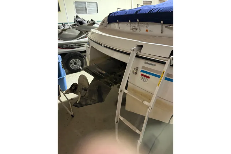 Slide: The Image of 1999 Four Winns 220 Horizon boat with ladder and covered deck in storage. - 12