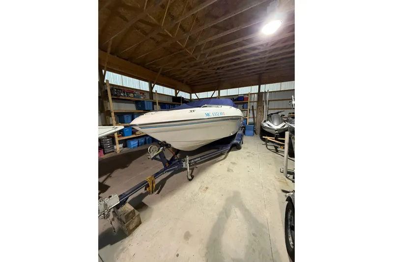 Slide: The Image of 1999 Four Winns 220 Horizon boat stored indoors on a trailer. - 2