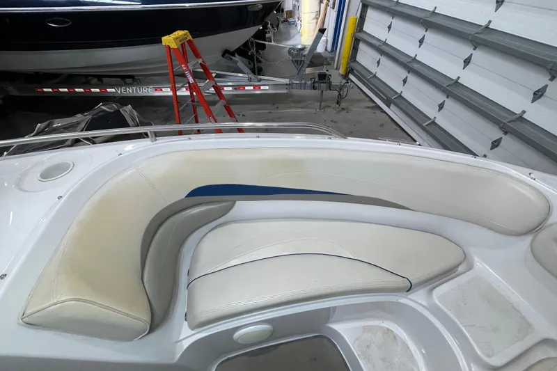 Slide: The Image of 1999 Four Winns 220 Horizon boat interior with white seating in a garage setting. - 20