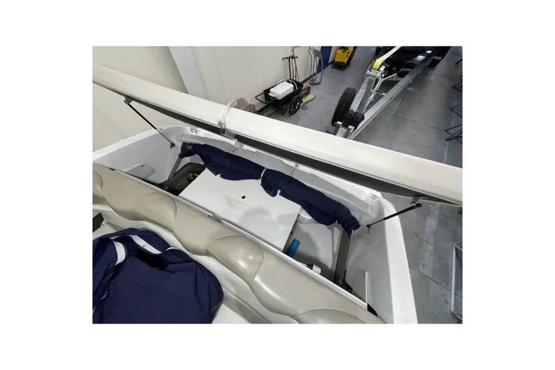 Slide: The Image of 1999 Four Winns 220 Horizon boat interior with open storage compartment. - 23