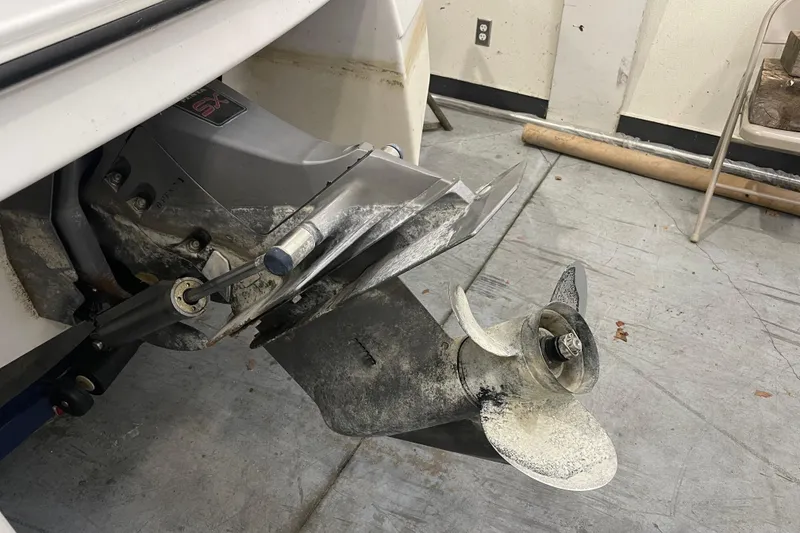 Slide: The Image of 1999 Four Winns 220 Horizon boat propeller and outdrive in a garage setting. - 27