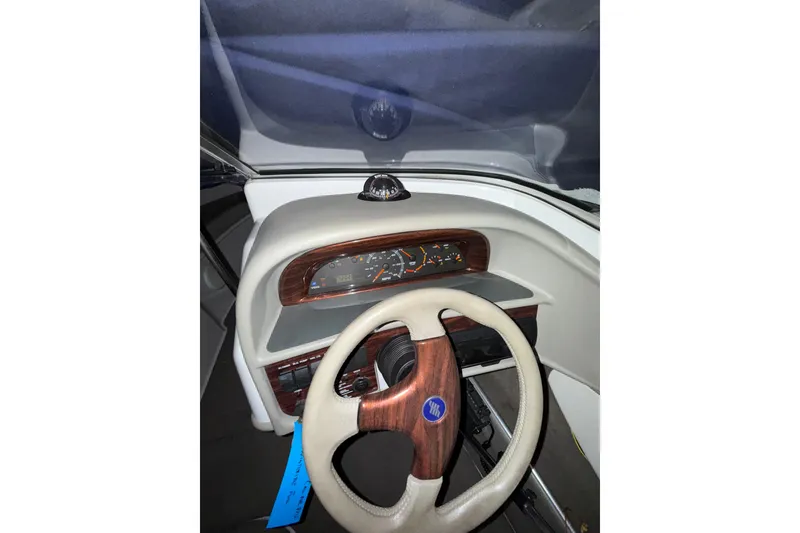 Slide: The Image of 1999 Four Winns 220 Horizon boat dashboard with wood-accented steering wheel and gauges. - 8