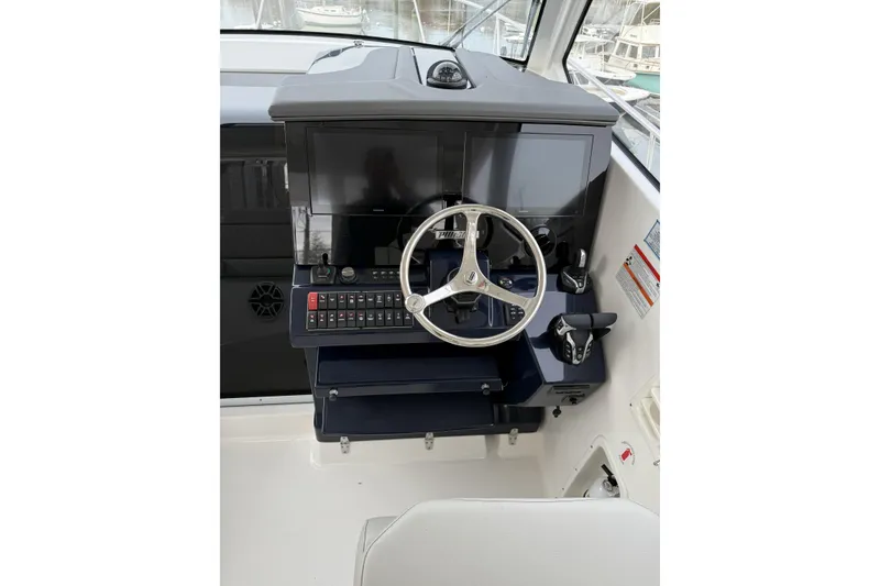 Slide: The Image of Helm of 2026 Pursuit OS 355 Offshore boat with modern controls and steering wheel. - 6