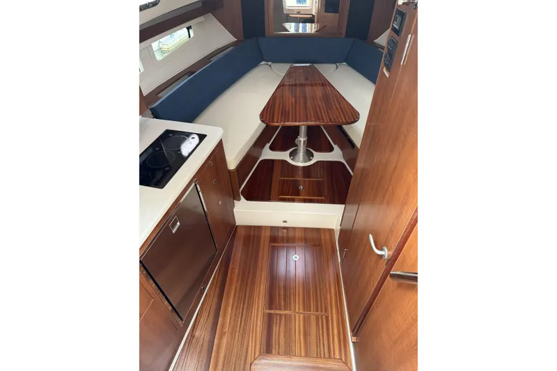 Slide: The Image of 2026 Pursuit OS 355 Offshore cabin interior with wood finish and compact kitchen area. - 7