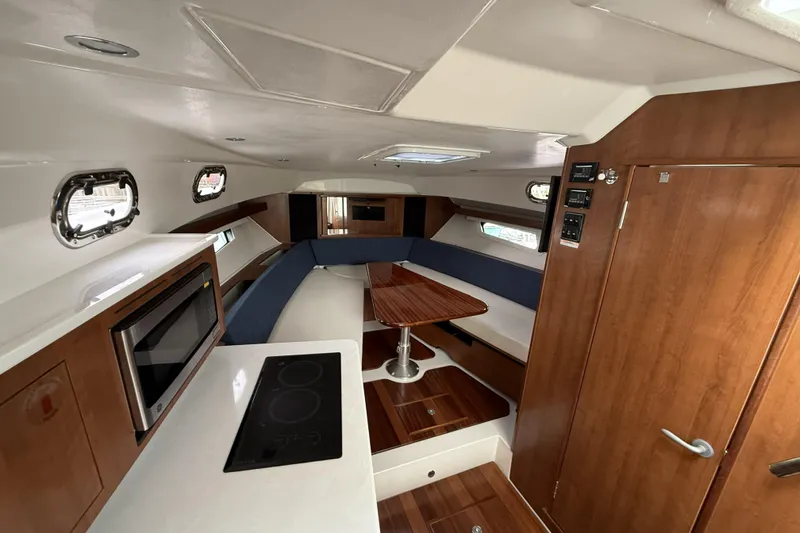 Slide: The Image of 2026 Pursuit OS 355 Offshore cabin interior with modern kitchen and seating area. - 9