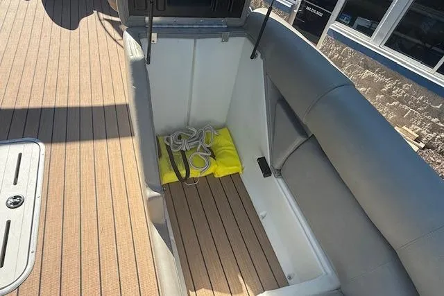 Slide: The Image of Open storage compartment on 2019 Premier 260 Grand Entertainer boat with rope and life jacket. - 16