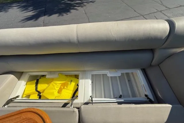 Slide: The Image of 2019 Premier 260 Grand Entertainer boat seat storage with life jackets visible. - 24