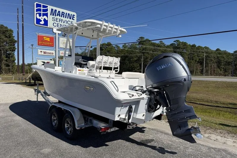 Slide: The Image of 2026 Sea Hunt Ultra 235 SE boat on trailer, parked outdoors under clear sky. - 2