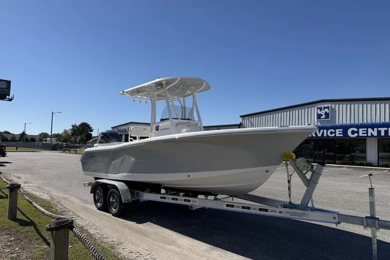 Slide: The Image of 2026 Sea Hunt Ultra 235 SE boat on trailer under clear blue sky. - 4