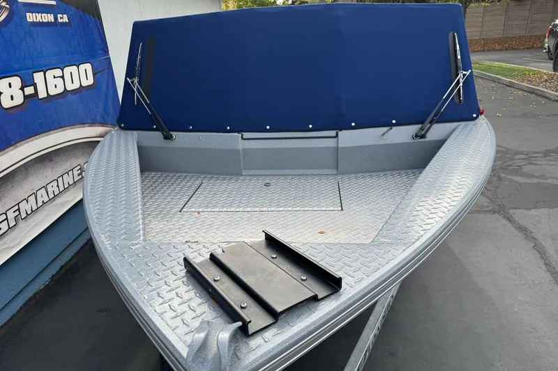 Slide: The Image of 2014 KingFisher 1625 Falcon XL boat with blue cover, parked outdoors. - 4
