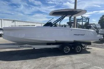 The Image of 2022 Axopar 22 TT boat on trailer, parked outdoors under a clear sky. - 0