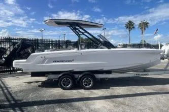 Slide: The Image of 2022 Axopar 22 TT boat on trailer, parked outdoors under a blue sky. - 1