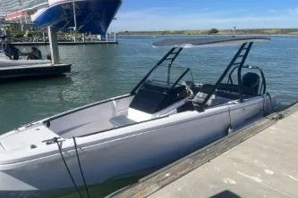 Slide: The Image of 2022 Axopar 22 TT boat docked in a marina under clear skies. - 13