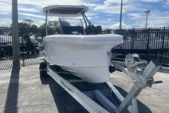 Slide: The Image of 2022 Axopar 22 TT boat on trailer, parked outdoors under a clear sky. - 3