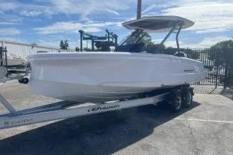 Slide: The Image of 2022 Axopar 22 TT boat on trailer, parked outdoors under a clear sky. - 4