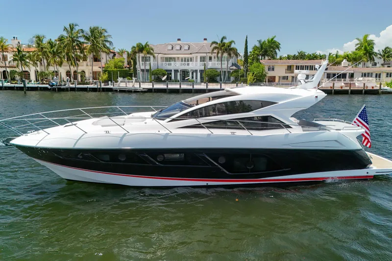 The Image of 2017 Sunseeker Predator 57 yacht cruising near waterfront homes, displaying sleek design and luxury. - 0