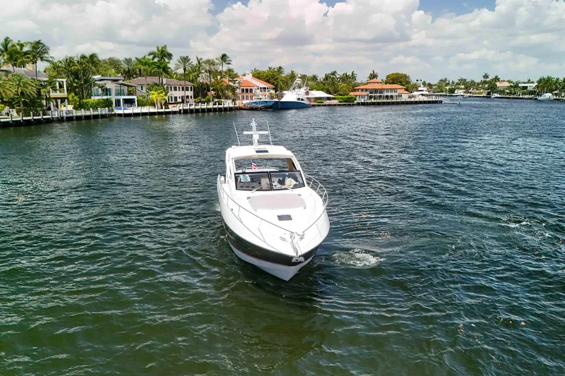 Slide: The Image of 2017 Sunseeker Predator 57 yacht cruising in a scenic waterfront area. - 61