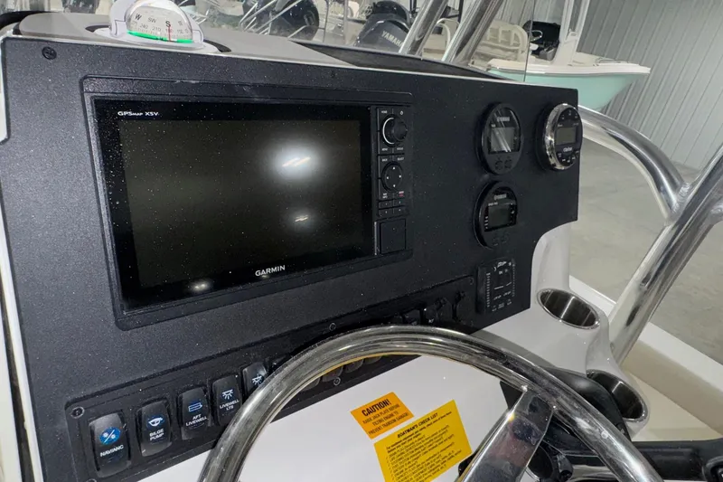 Slide: The Image of 2026 Key West 230 Bay Reef dashboard with Garmin GPS and control panel. - 18